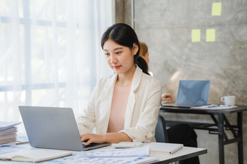 Portrait of Asian young female working on laptop at office