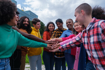 Group of ethnically diverse young people joining hands