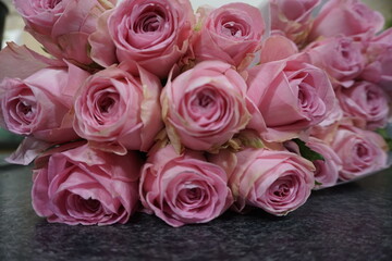Pinke frische Rosen auf schwarzer Marmortheke 