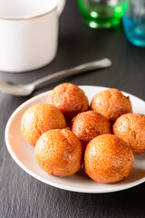 fried semolina balls on a plate, served savory treat and light snack for tea time, closeup view of a sweet balls taken in shallow depth of field