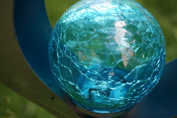 Blaue Glaskugel mit Muster in blauer Metallfassung 