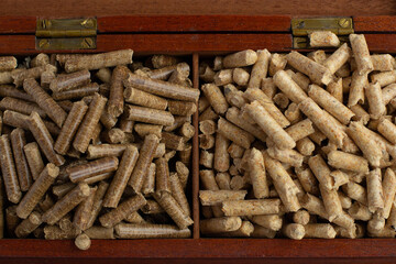 wood pellets for firebox, light and dark for comparison, elite pellets in a wooden box, beautifully designed, eco product, for a catalog