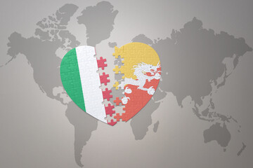 puzzle heart with the national flag of bhutan and italy on a world map background. Concept.