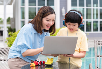 Mother with cute son use headphone at outside home	