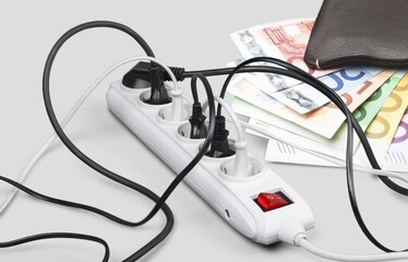 Electric power supply concept. Power cords cable plugged in open wallet placed. Payment of electricity and heating bills.