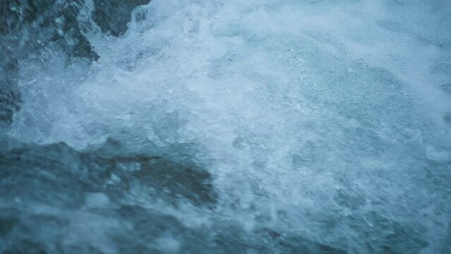 Close up of water splashes from a wild mountain river. Slow motion, 