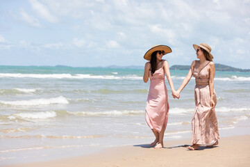 romantic young lesbian couples in love and walking together on the beach