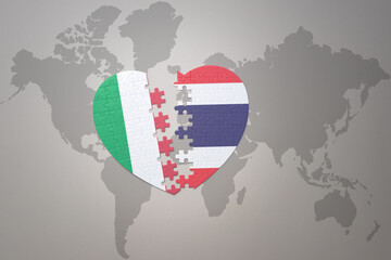 Obraz premium puzzle heart with the national flag of thailand and italy on a world map background. Concept.