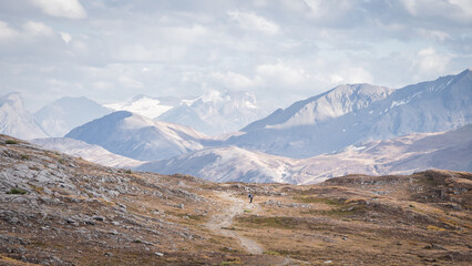 Fototapeta premium Hikers walking through stunning alpine valley in Canadian Rockies during fall,Jasper N.Park,Canada