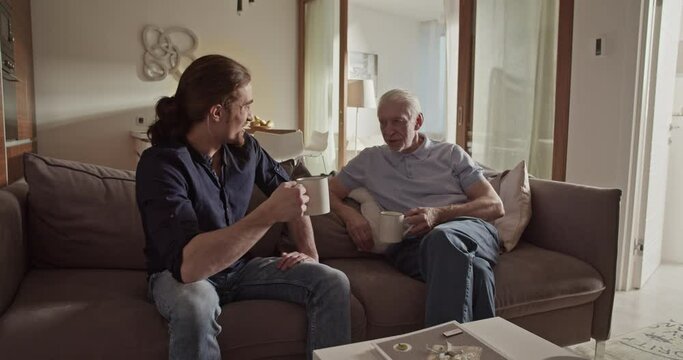 Father and son speaking on sofa