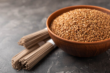 Buckwheat paste with buckwheat porridge on a black cement background. Raw noodles. Ingredients for a gluten-free dish. Dried buckwheat soba noodles.Traditional Japanese food.Health food.Copy space.