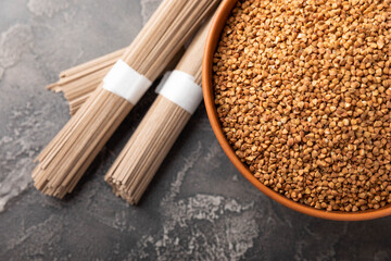 Buckwheat paste with buckwheat porridge on a black cement background. Raw noodles. Ingredients for a gluten-free dish. Dried buckwheat soba noodles.Traditional Japanese food.Health food.Copy space.