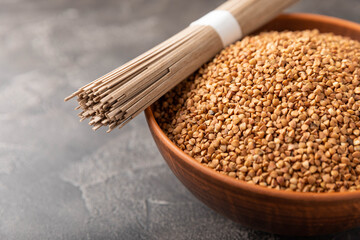Buckwheat paste with buckwheat porridge on a black cement background. Raw noodles. Ingredients for a gluten-free dish. Dried buckwheat soba noodles.Traditional Japanese food.Health food.Copy space.