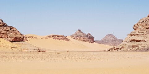 Fototapeta na wymiar Panorama d'un ouadi dans le Sahara libyen, avec les formations rocheuses de l'Akakus