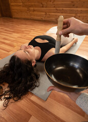 Latin woman receiving a soundhealing therapy with tibetan bowls