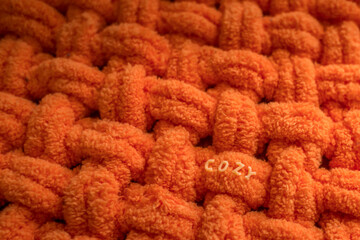 Plush plaid. Soft yarn for knitting. Cozy knitted background. Knit by hand. Home comfort. Handmade product. Women's hobby. Yarn texture.