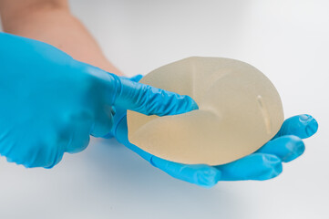 A plastic surgeon shows a breast silicone implant.