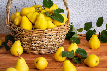 Basket with ripe juicy yellow dream pears close-up wooden table