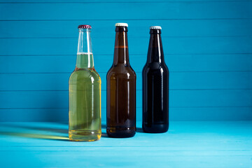 bottles with craft beer on a blue background.  Ale or lager from pilsner malt.  homemade home-brewed beer. - obrazy, fototapety, plakaty