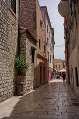 Sibenik, Croatia - May 26, 2022 - narrow old street and yard in Sibenik city, medieval zone