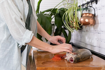 Female hands cutting fillet of red fish. Red caviar. Removing fish bones. Butchering red fish...