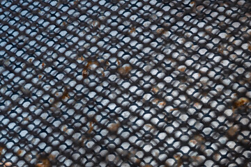 Metal grid silhouette against rusty plate. Background image