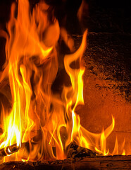 Flames of fire and hot coals of burned wood in the fireplace
