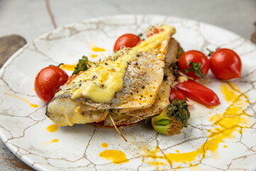 baked sea bream fish with tomatoes, peppers, sauce and broccoli

