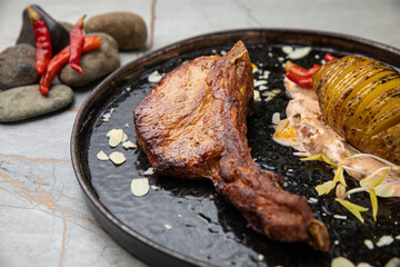 The meat is grilled, with bone, fried potatoes, sauce. 