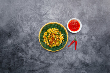 Obraz na płótnie Canvas Fried corns with bacons with chili sauce served in bowl isolated on dark grey background top view of japanese food