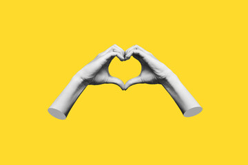 Human female hands showing a heart shape isolated on a yellow color background. Feelings and...
