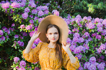 girl in a straw hat in a blooming garden