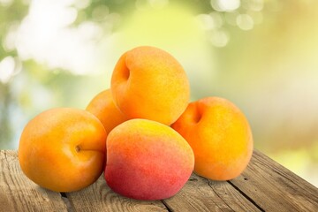 Orange fresh ripe apricots with leaves on a wooden table
