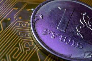 A coin with a face value of 1 ruble lies on a microcircuit. close-up. Translation of the inscription on the coin: 