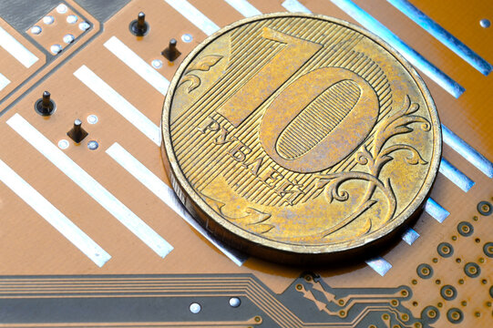 A coin with a face value of 10 rubles lies on a microcircuit. close-up. Translation of the inscription on the coin: "10 rubles" The concept of the digital economy in the Russian Federation
