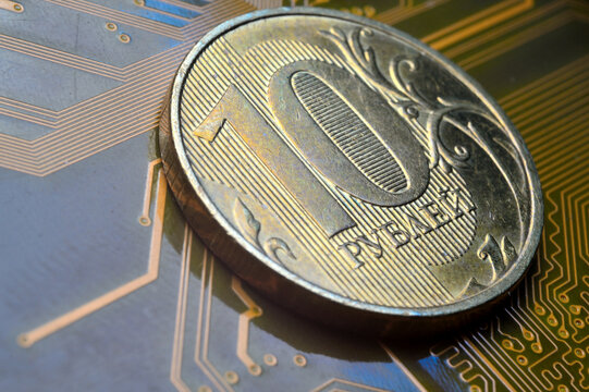 A coin with a face value of 10 rubles lies on a microcircuit. close-up. Translation of the inscription on the coin: "10 rubles" The concept of the digital economy in the Russian Federation