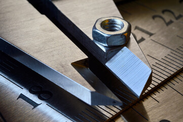 Accurate measuring tool caliper and metal ruler lie in place with nuts. close-up.