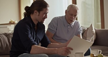 Father and son examining photos together