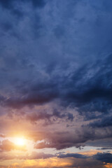 Thunderclouds with breaking rays sun at sunset.