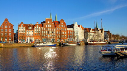 Fototapeta na wymiar Museumshafen in Lübeck mit alten Schiffen auf der Trave und malerischen Hausfassaden 