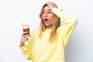 Young Uruguayan woman holding Frappuccino isolated on white background doing surprise gesture while looking to the side