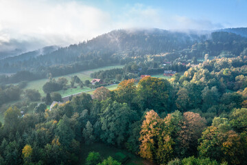 Foggy morning at the forest and green mountains. Beautiful autumn colors.