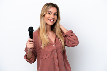 Singer Uruguayan woman picking up a microphone isolated on white background laughing