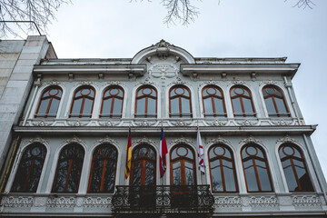 Beautiful old centuries building with neoclassical architecture, ornaments, flags and balconies in a cloudy day, Valdivia, Chile