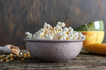Freshly cooked popcorn in a bowl on a wooden table. Rustic style.