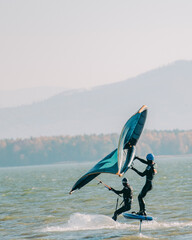 Wingfoil swimming on a board with a kite. Modern sport, activity, joy and happiness on the water