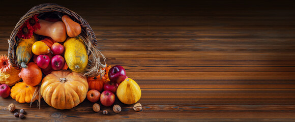 Thanksgiving day background with empty copy space. Pumpkin harvest in wicker basket. Squash, orange...