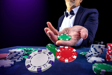 Gambling concept. Close up of casino bettor male hand throwing Сasino chips or Casino tokens at gambling club. Dice, poker cards, gambling man lucky guy spending time in games of chance at casino