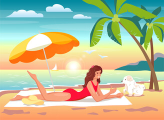 Woman is sunbathing on a towel and playing with a dog under a summer umbrella 