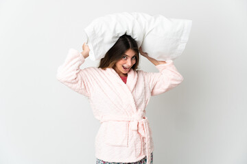 Young caucasian woman isolated on white background in pajamas and holding a pillow stressed overwhelmed